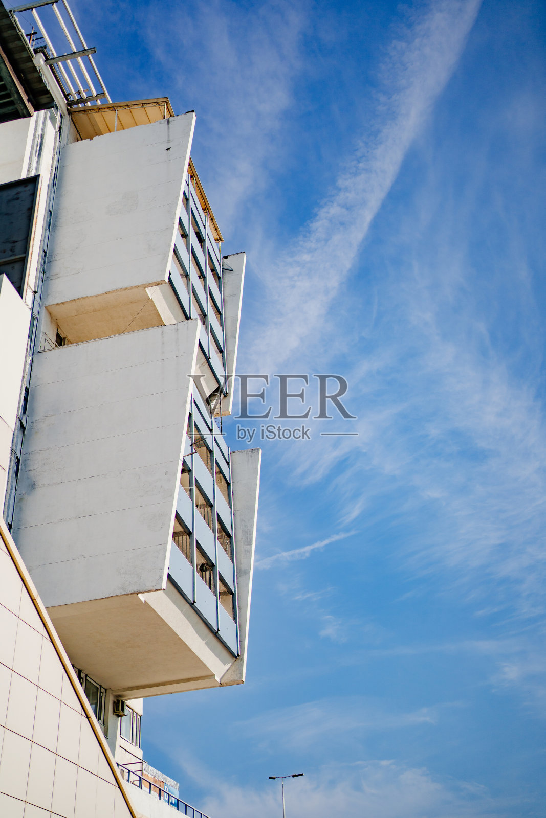 大楼的阳台映衬着蓝天。照片摄影图片