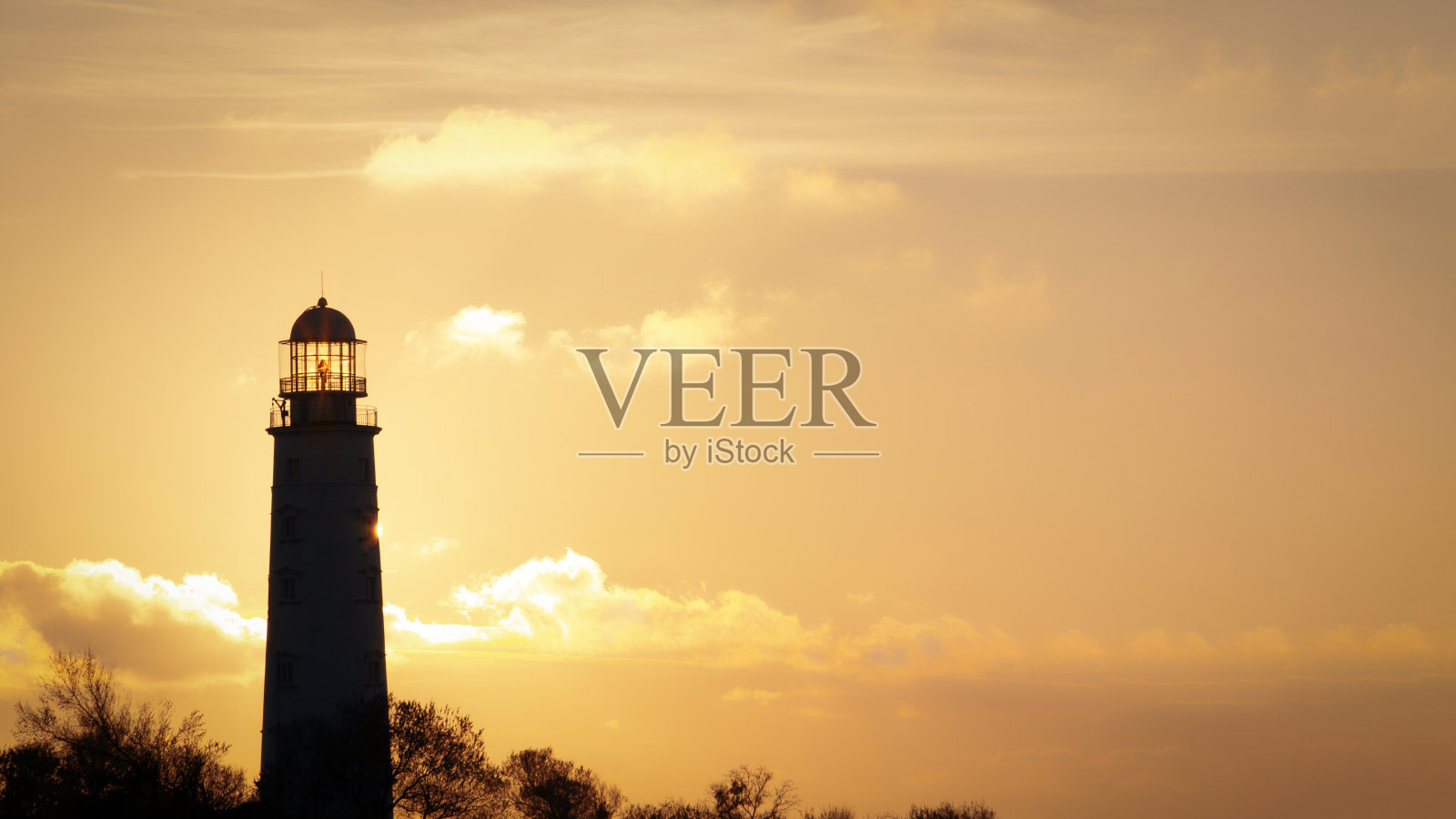 太阳透过的日落灯塔照片摄影图片