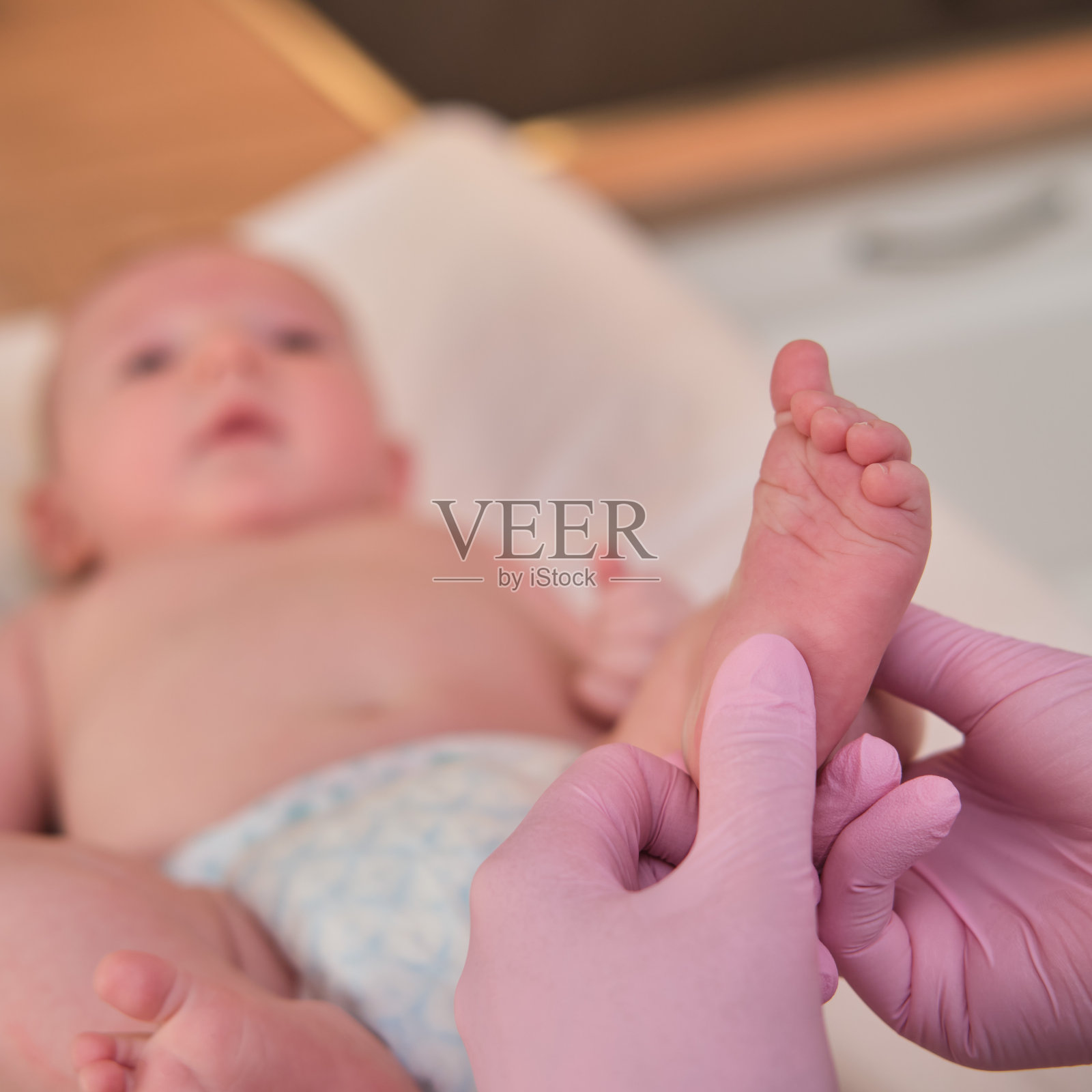 医生为新生婴儿做体操和按摩，护士为孩子做热身运动照片摄影图片