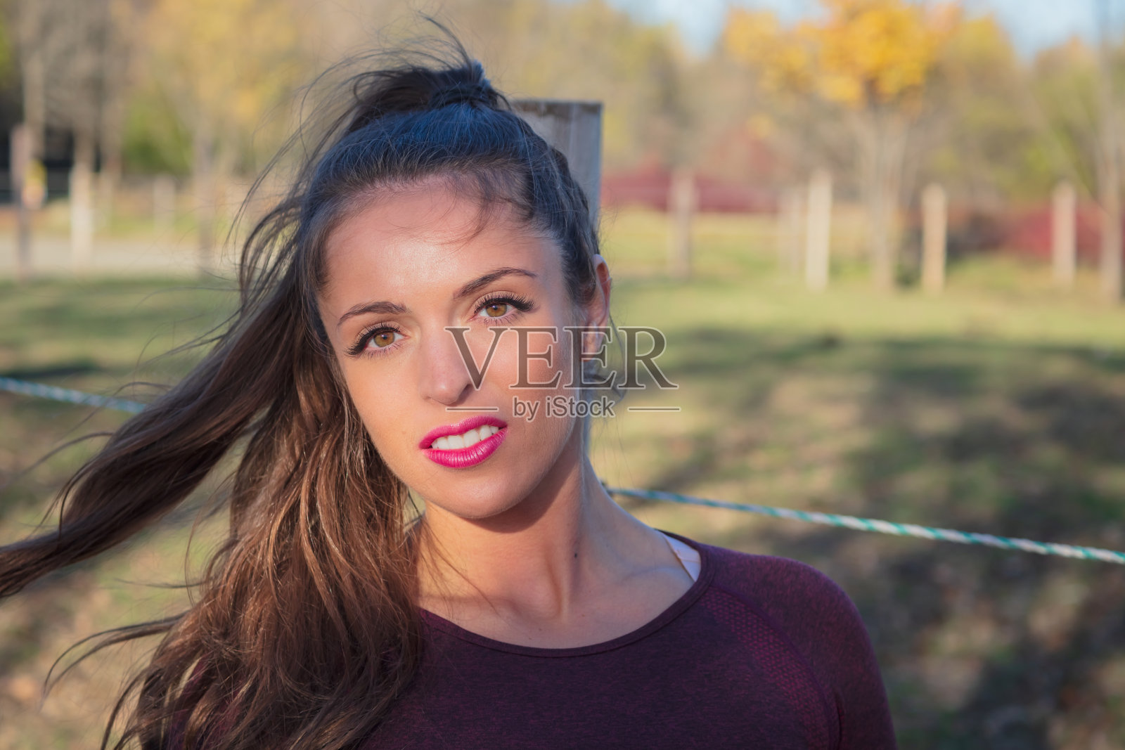 20多岁的年轻女子，自然的棕色长发，在阳光下摆姿势照片摄影图片