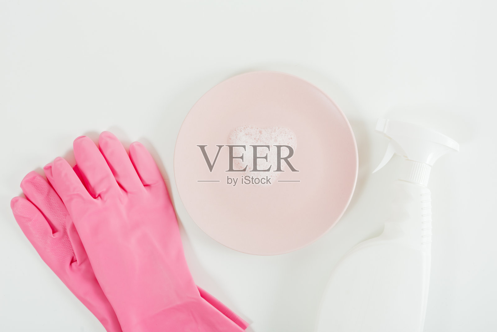 洗菜的概念。粉色手套，心形泡沫板，白色喷雾瓶。白色背景。平铺，复制空间照片摄影图片