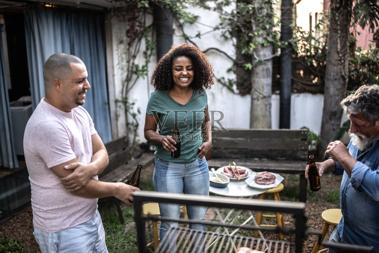 家人在家里烧烤架旁聊天喝酒照片摄影图片