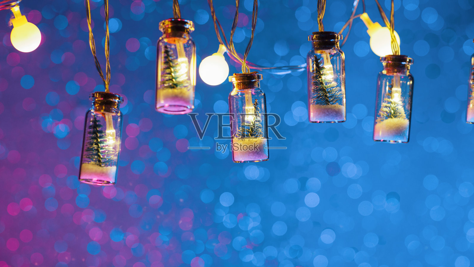 玻璃罐花环中的小型圣诞树，圣诞快乐背景，霓虹灯散景照片摄影图片