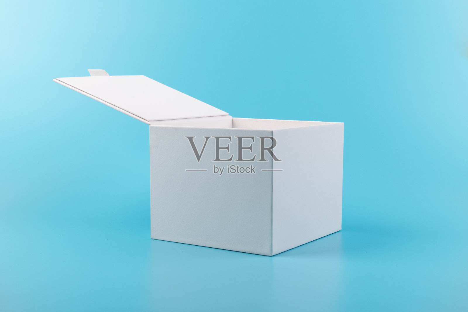 蓝色背景上打开的白色纸盒。照片摄影图片