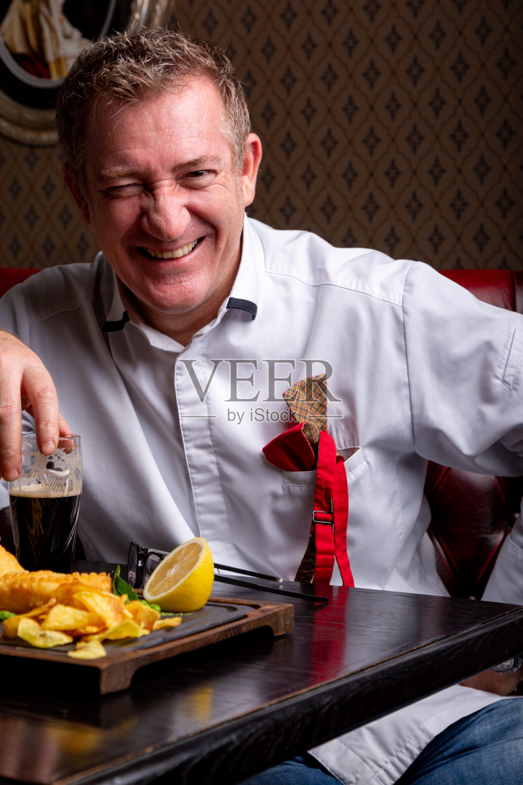 适合任何年龄。时尚的50岁男人的肖像在时尚的姿势在餐厅。时髦的发型，光滑的灰发。近距离照片摄影图片