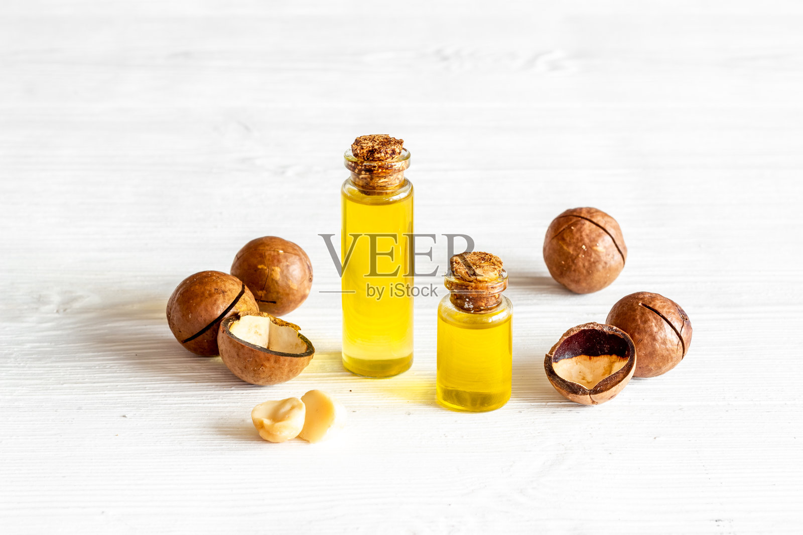 澳洲坚果油在玻璃瓶中与坚果。特级初榨精华油，用于食品或化妆品照片摄影图片