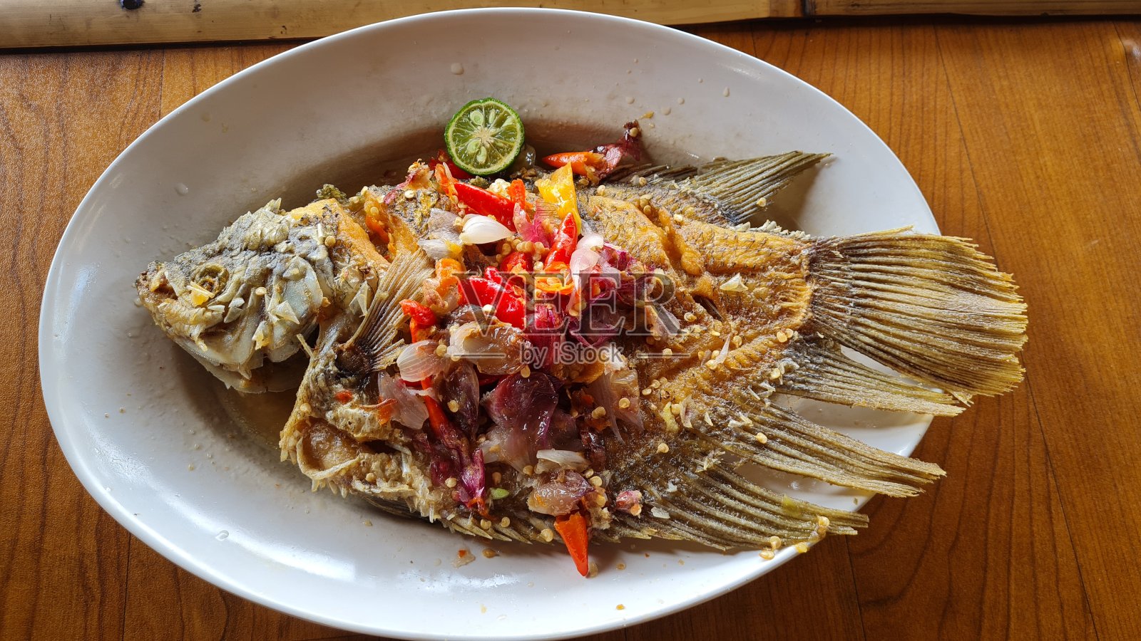 烤制的丝瓜鱼放在白色的瓷盘上即可食用照片摄影图片