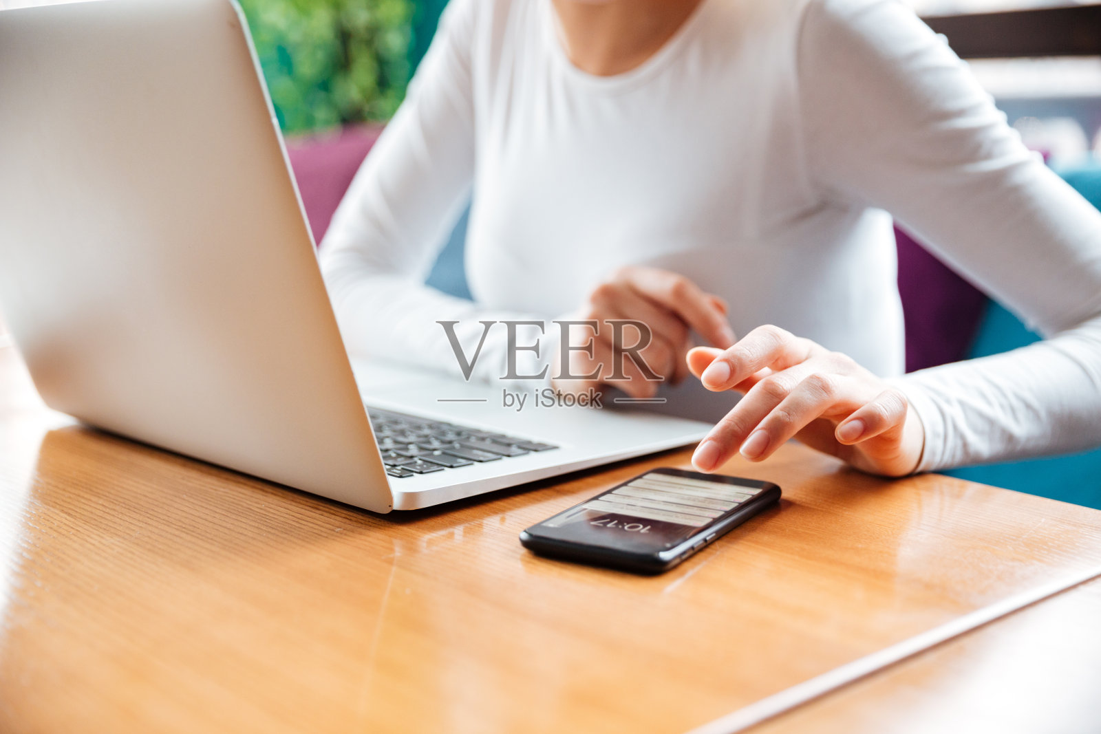 年轻女士使用笔记本电脑和手机的裁剪图像照片摄影图片