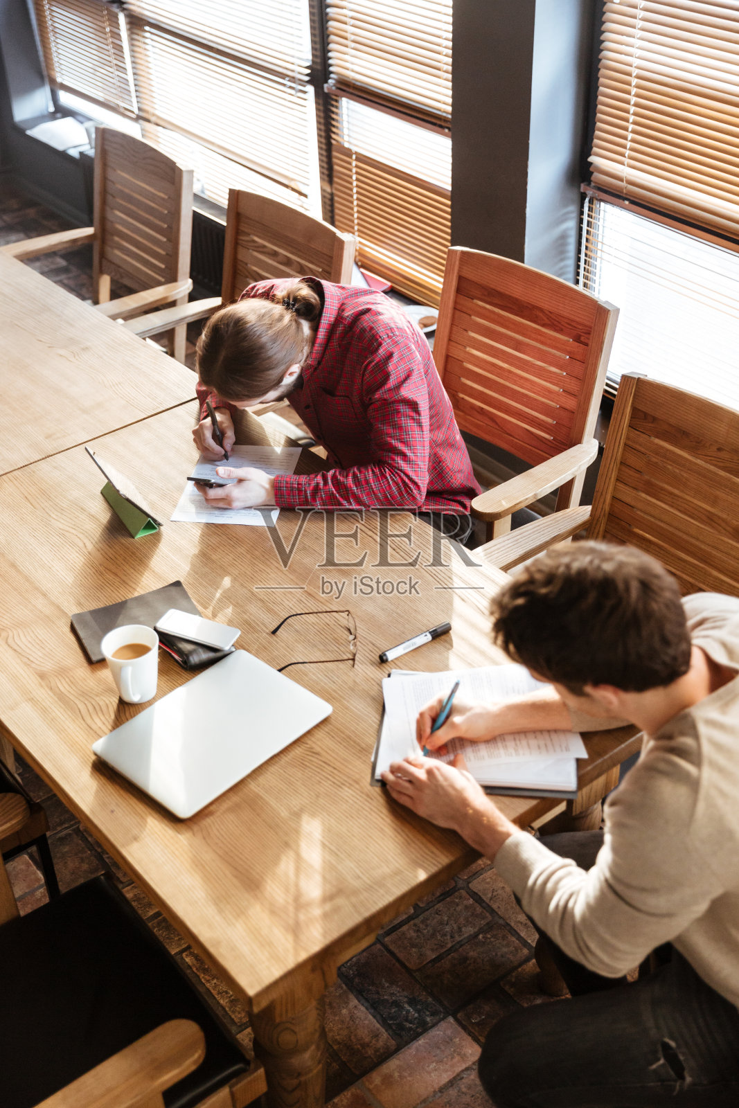 年轻的同事们在办公室专心地做笔记照片摄影图片