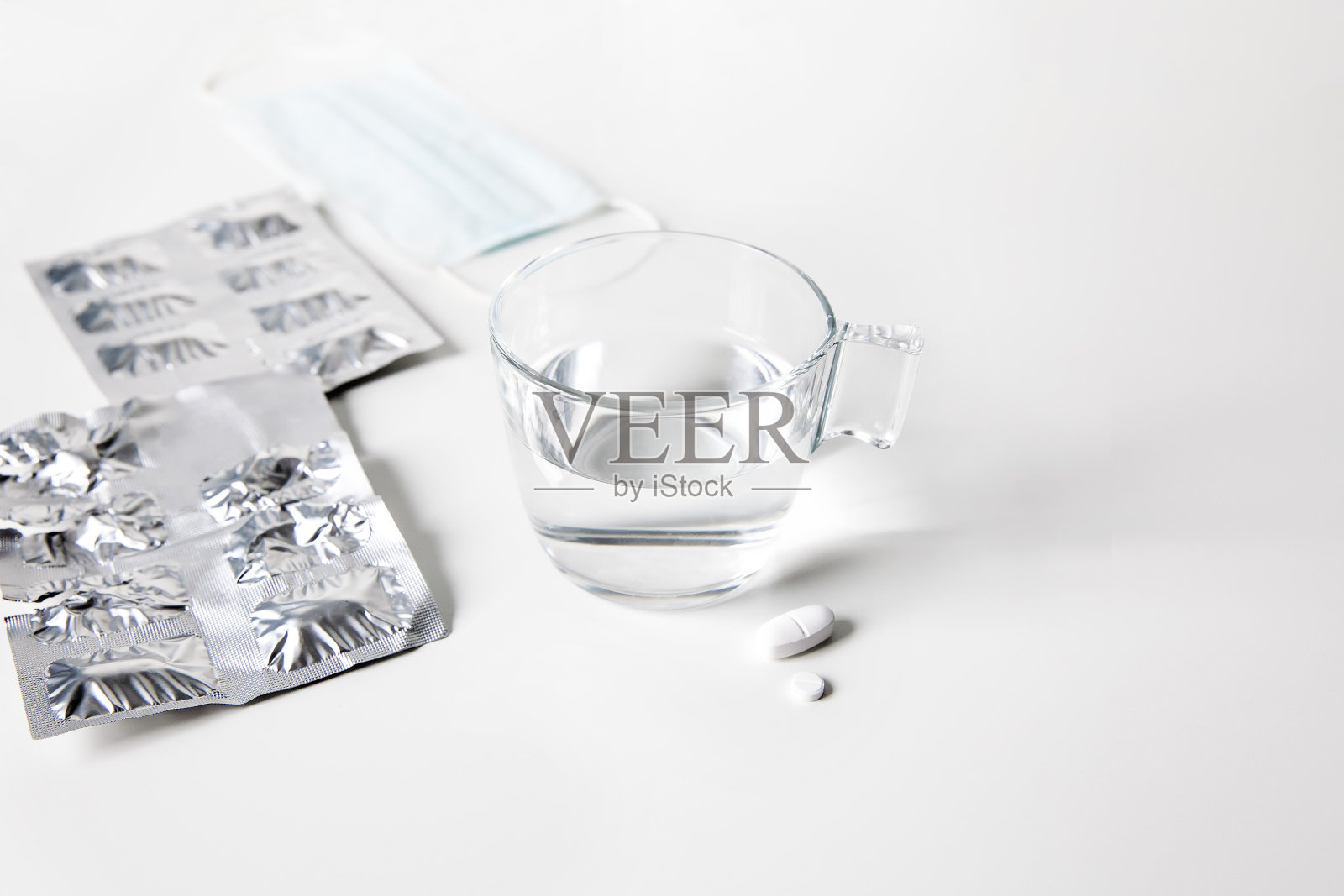 水泡药丸和白色背景的一杯水照片摄影图片