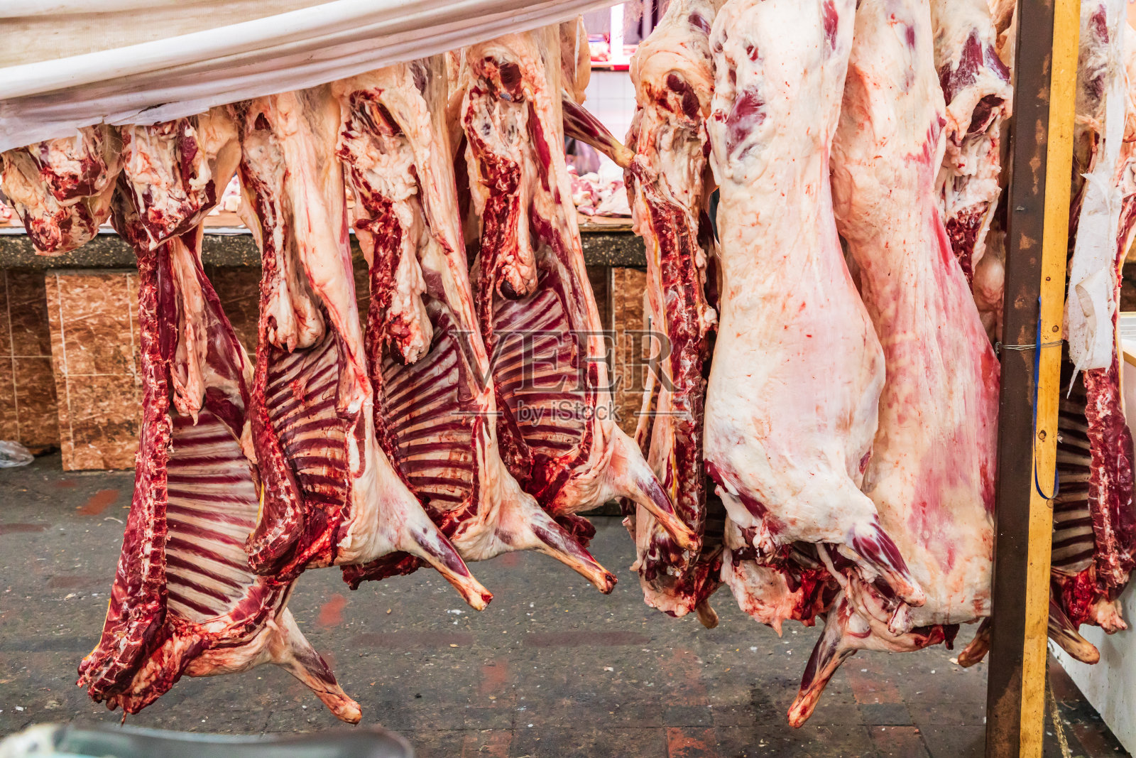 在Khujand的Panjshanbe集市上，肉店里的动物尸体。照片摄影图片