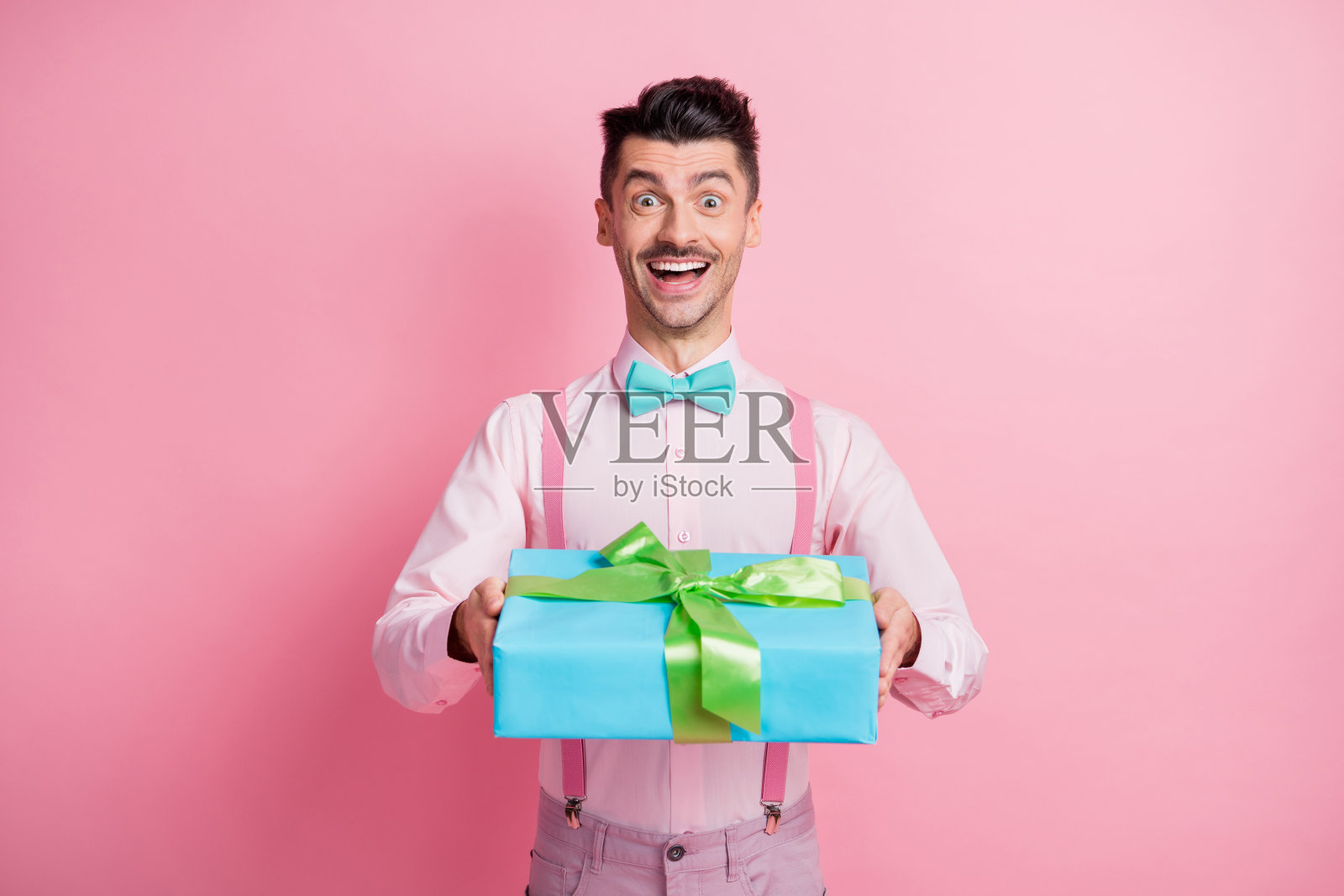 照片肖像愉快的家伙收到礼物孤立在柔和的粉红色背景照片摄影图片