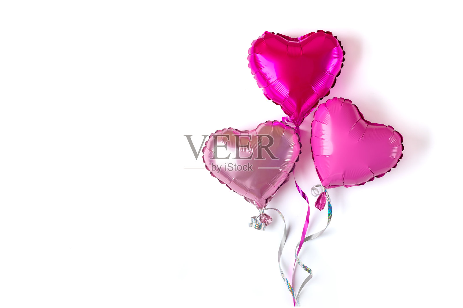 三个红色紫色哑光粉色心形充气玩具，白色背景，情人节生日派对概念照片摄影图片
