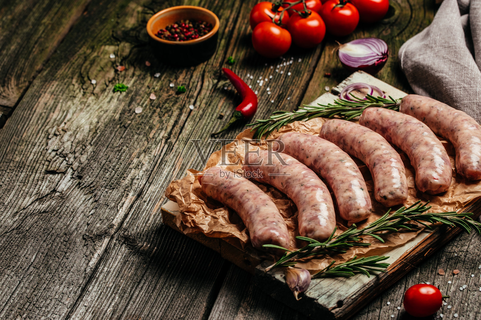 木制背景的切菜板上放着生香肠。横幅，菜单，文本的食谱地方，顶部视图照片摄影图片