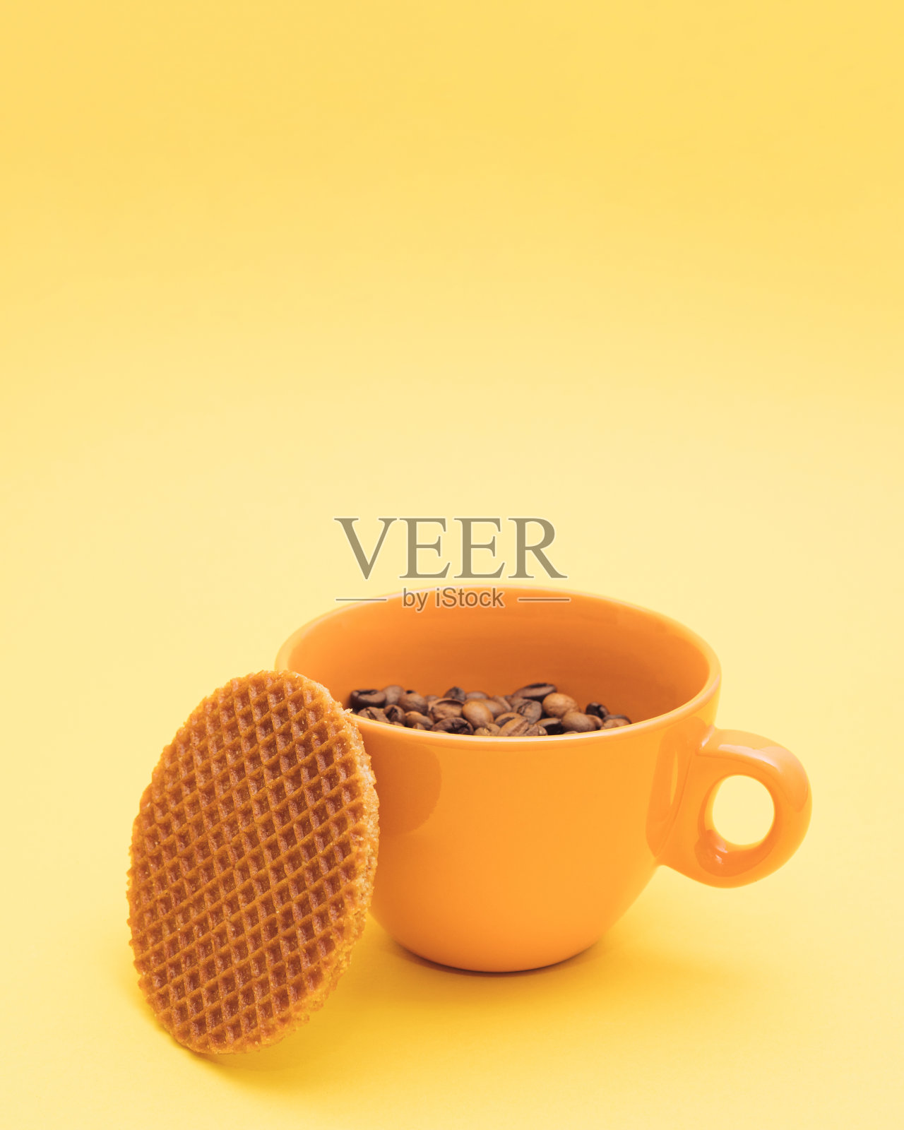 早餐是一杯黄色的咖啡豆和烤华夫饼。早上的例行工作在清新的马克杯在黄色背景。最小的香气的概念。照片摄影图片