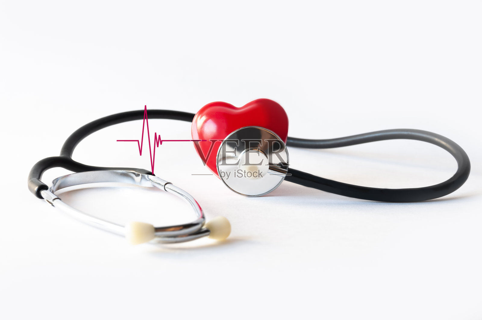 用声腔内窥镜模拟一个人的心脏，并在白色背景的特写照片上放一块心电图碎片。心脏病医学检查或心脏病检查的概念图像。照片摄影图片