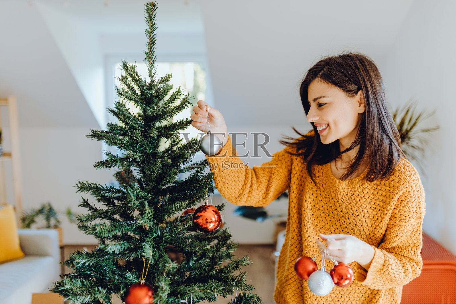 年轻女子为圣诞节装饰她的家照片摄影图片