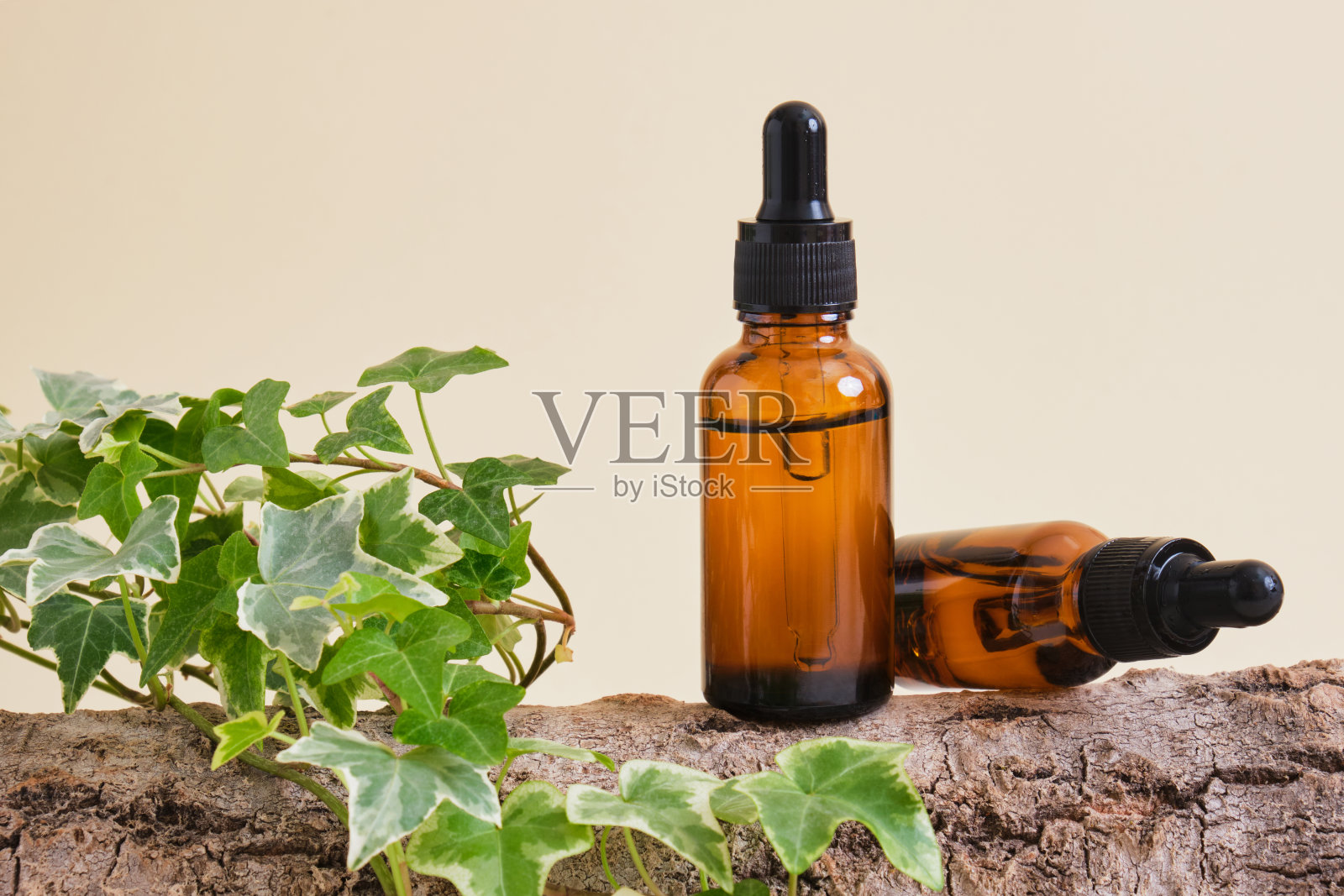 琥珀玻璃瓶与面血清或油树皮在米色背景照片摄影图片