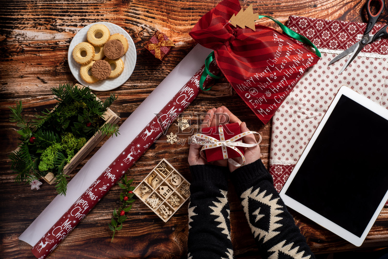 女人的手拿着礼物，同时包装圣诞礼物照片摄影图片