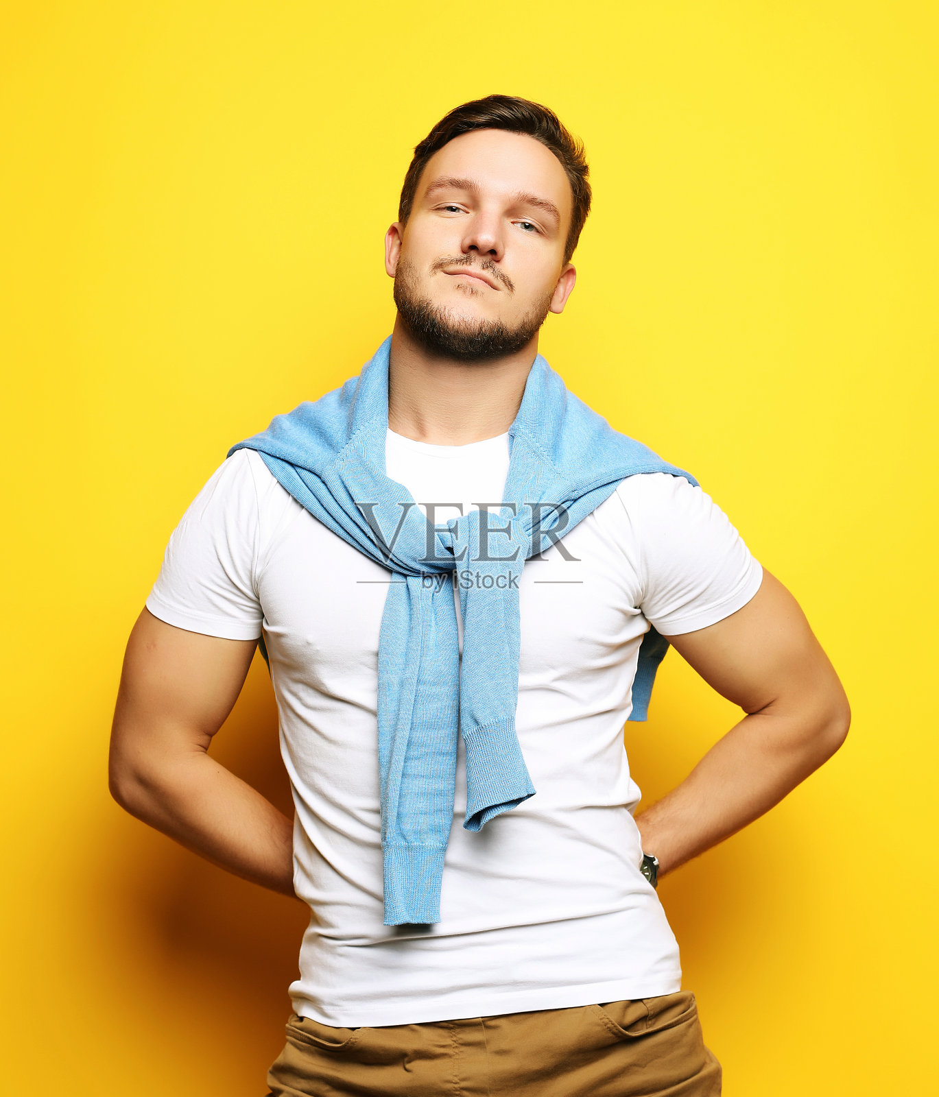 一个聪明的年轻人站在黄色背景下的肖像照片摄影图片