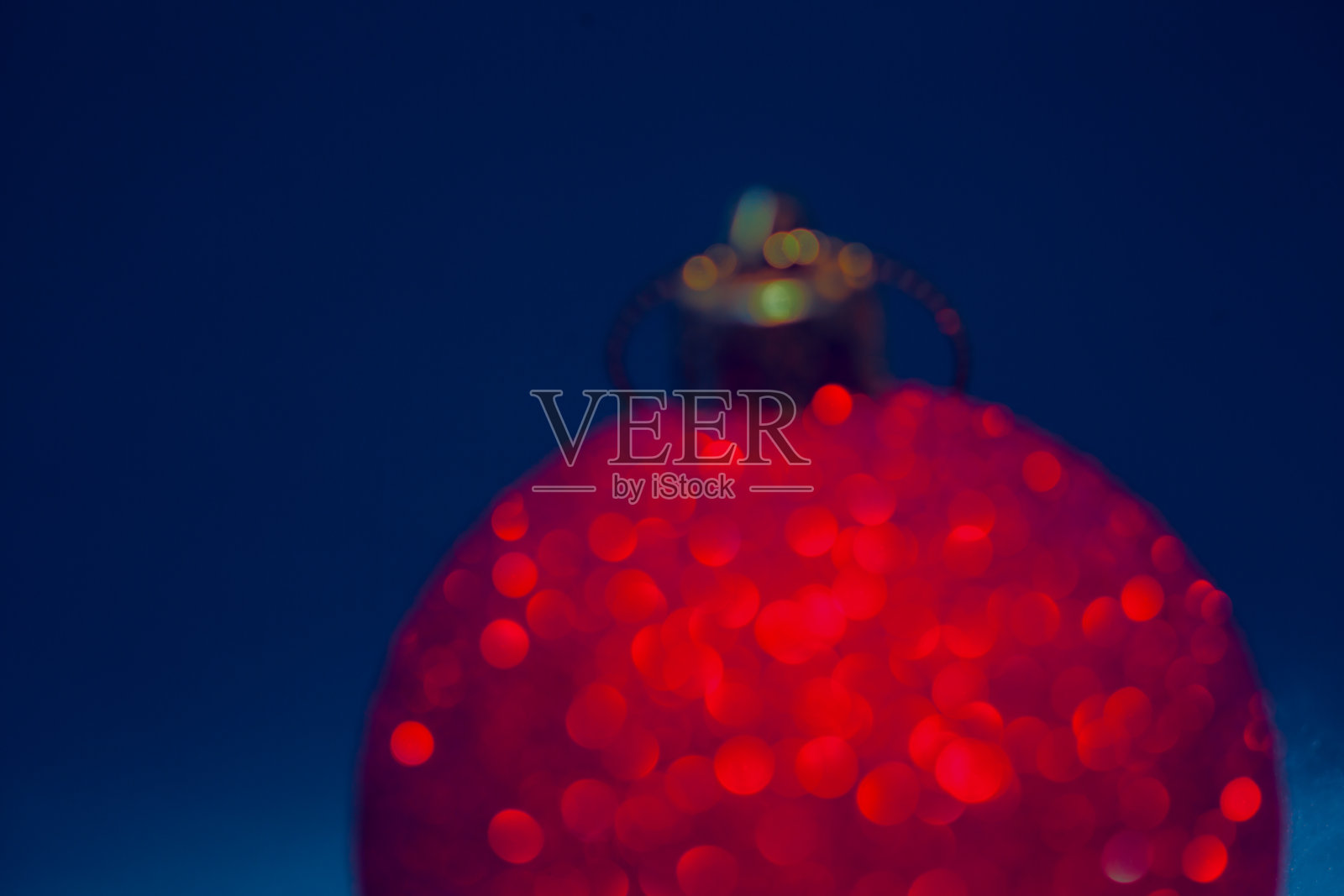 离焦圣诞红球背景上的蓝色照片摄影图片