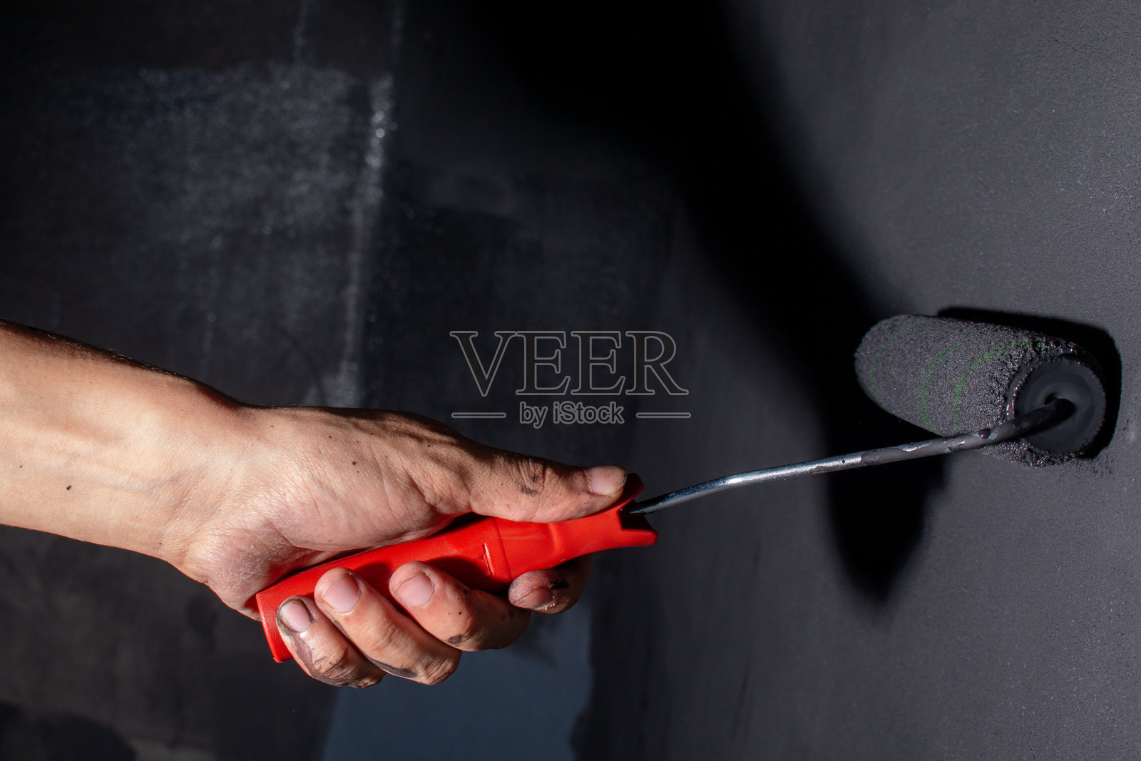 棕色的手画着黑色的墙。工艺工作的概念。照片摄影图片