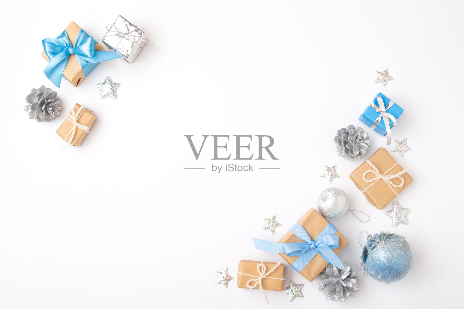 圣诞节或新年最小构图。框架旗帜浅蓝色的圣诞球，银星，松果和礼盒在白色的背景。前视图。平铺，复制空间。照片摄影图片