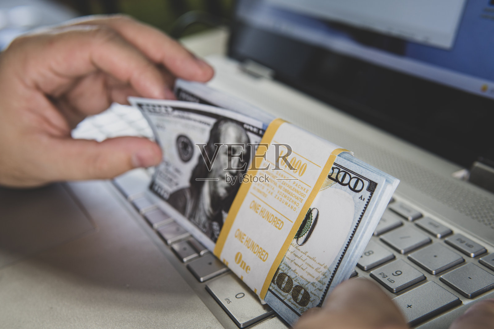 笔记本电脑和美元，电脑笔记本和美元纸币在一个木制背景，技术与美元纸币，在互联网上赚钱。在线工作。照片摄影图片