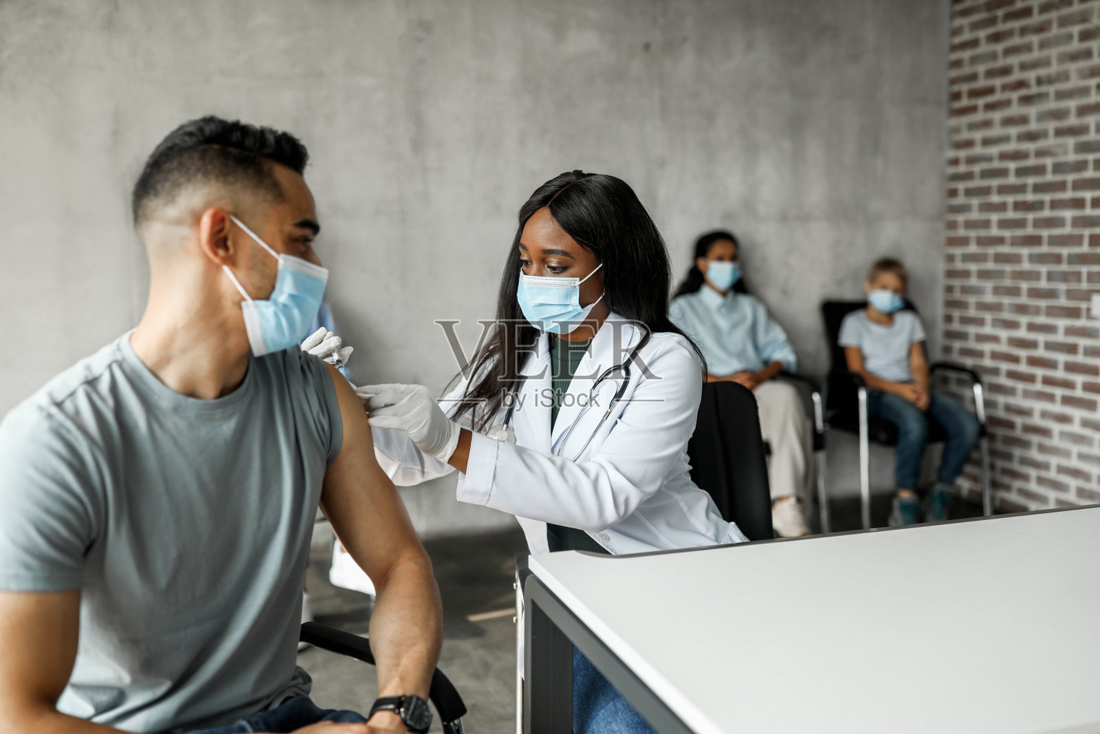 一名阿拉伯男子在诊所接受新型冠状病毒肌肉注射照片摄影图片