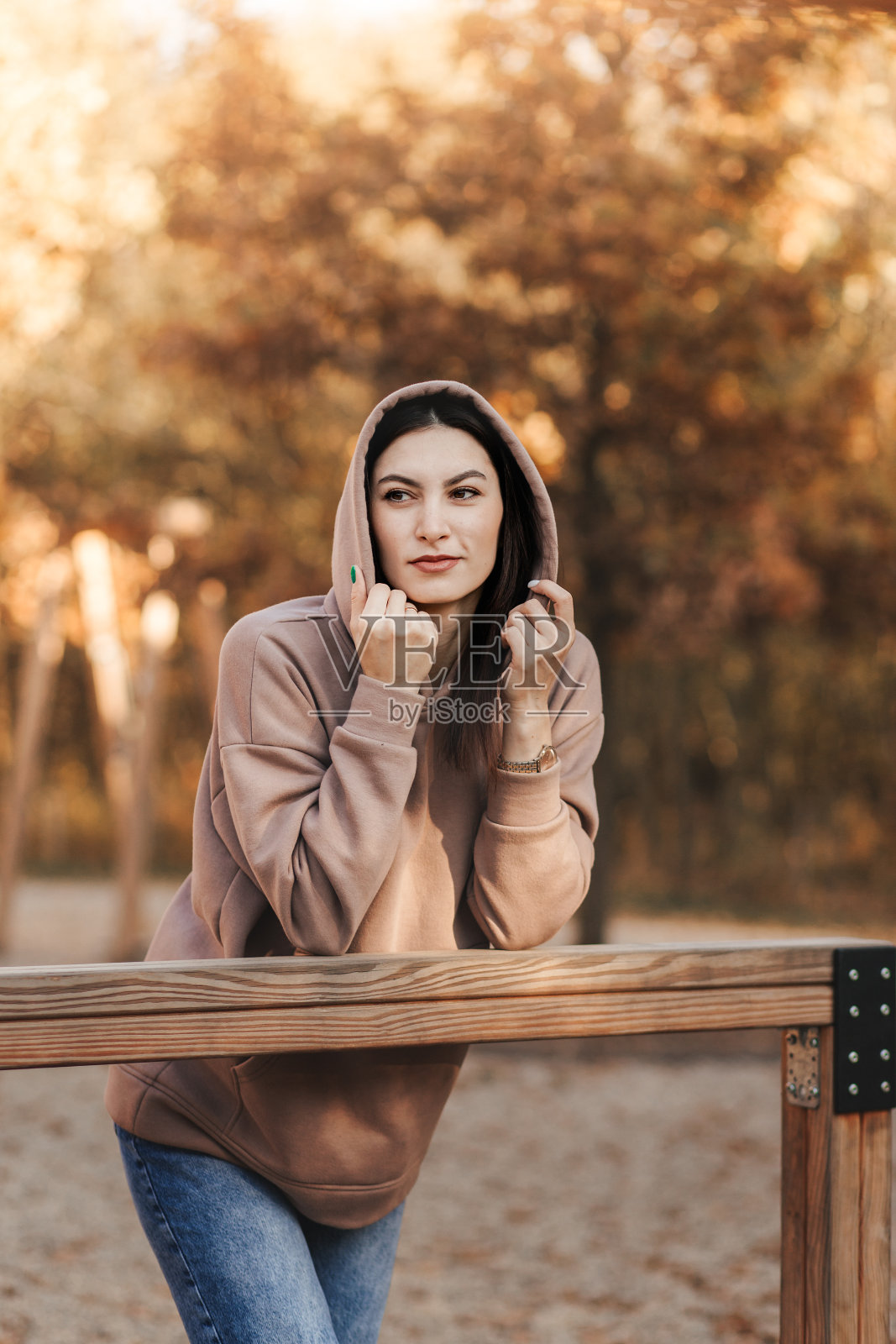 一个年轻的黑发女人在秋天的公园里。步行到城市的街道。照片摄影图片