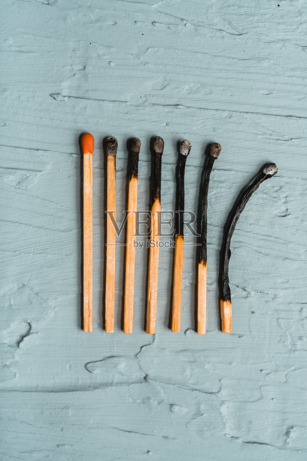 灰色背景上燃烧的火柴棒照片摄影图片