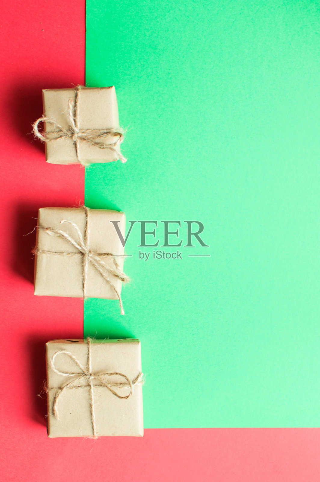 节日概念-礼物上有一个蝴蝶结和圆锥形的绿色和红色背景。照片摄影图片