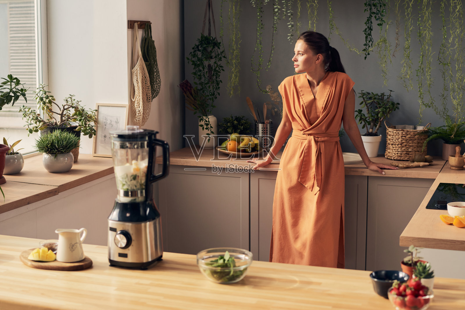 年轻安详的女人穿着衣服站在厨房里照片摄影图片