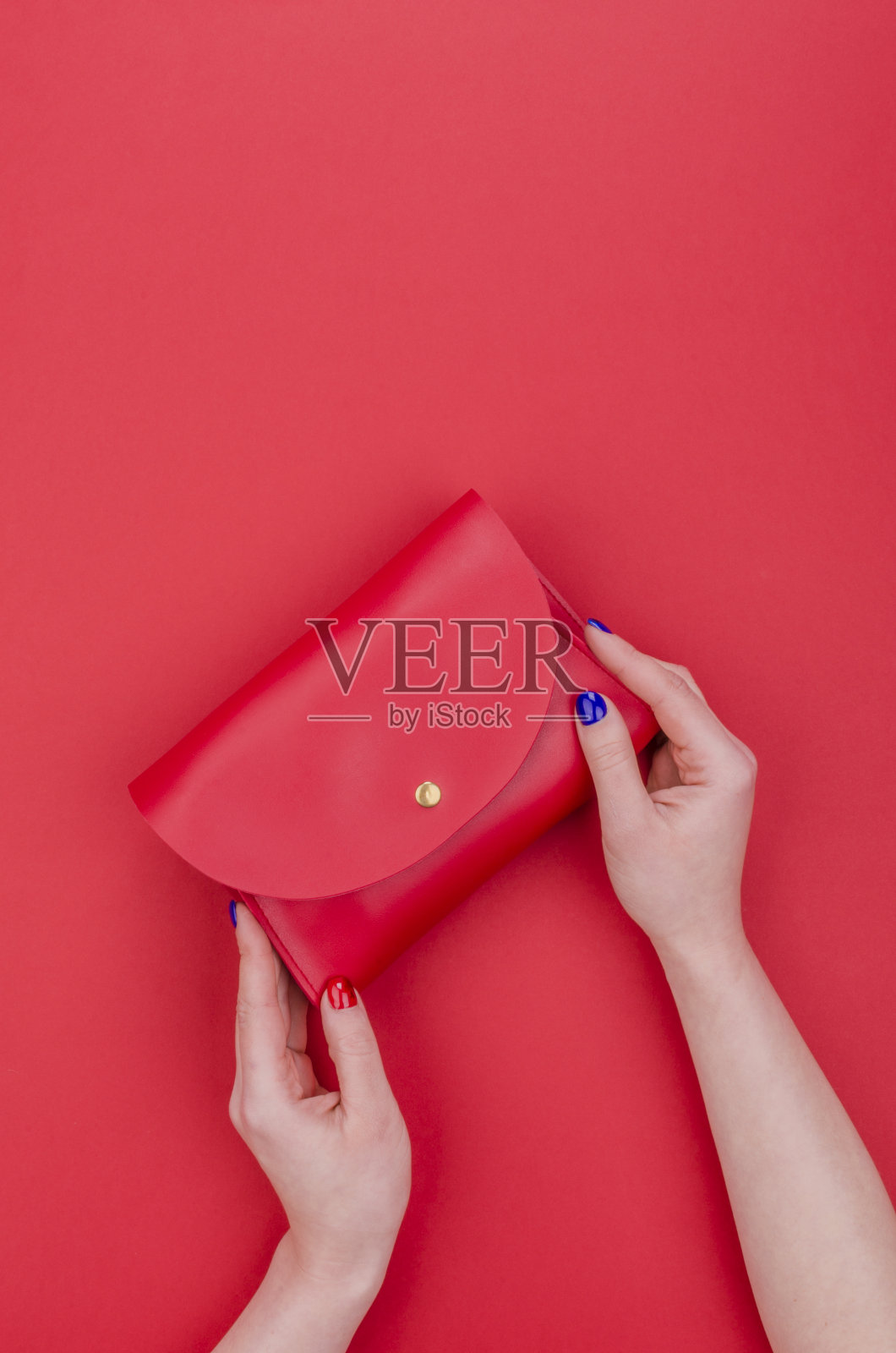 女人手拿鲜亮的指甲握着红色的手包照片摄影图片