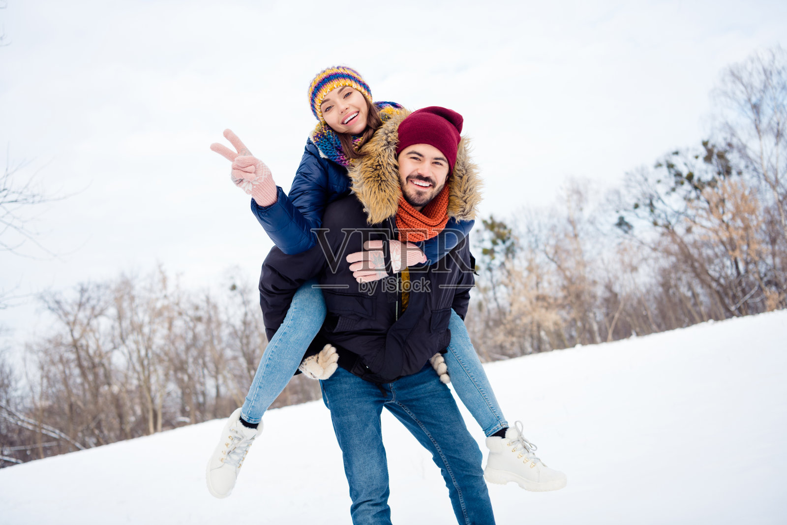 正面男人的照片，向后拉有吸引力的愉快的女士手指显示v字穿围巾靴子周末户外照片摄影图片
