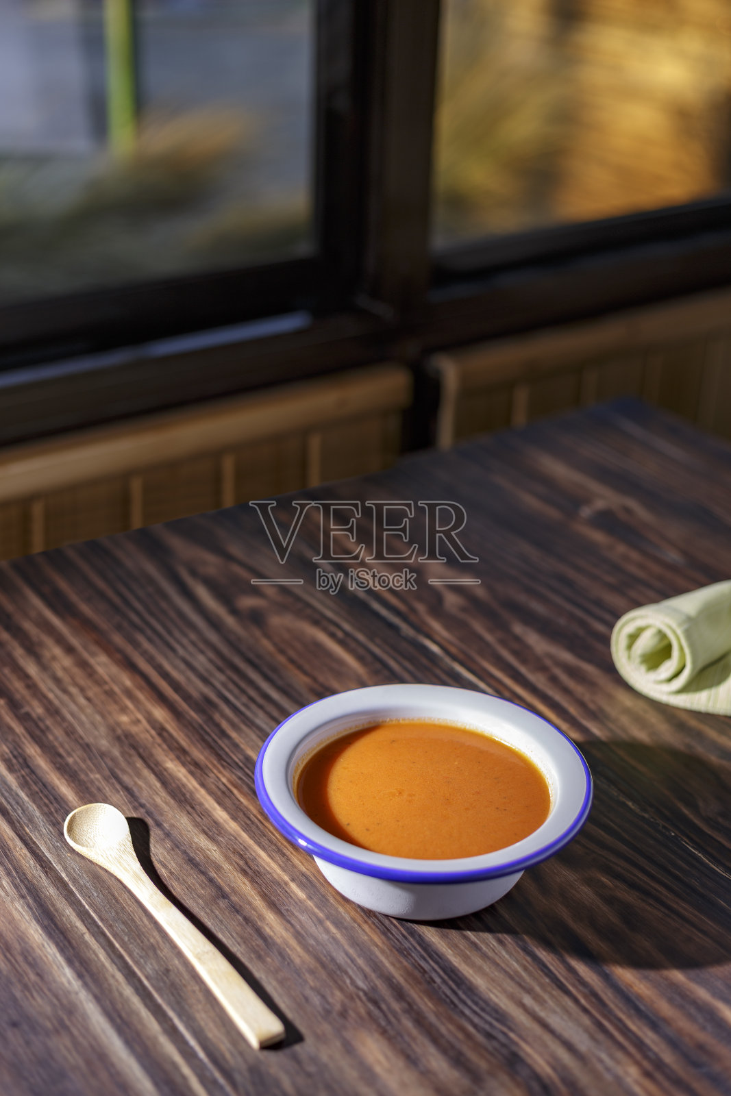 凉菜汤碗和番茄放在木桌上，窗外是花园照片摄影图片