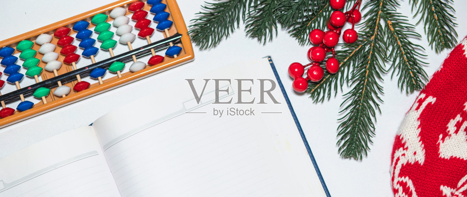 圣诞节空笔记本，日记为信给圣诞老人或你的愿望清单或降临活动在白色。心算得分算盘旁边的新年帽子和云杉树枝照片摄影图片