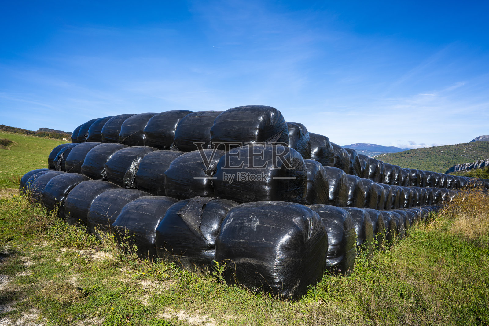 在纳瓦尔，用黑色塑料保护的稻草捆成一排照片摄影图片