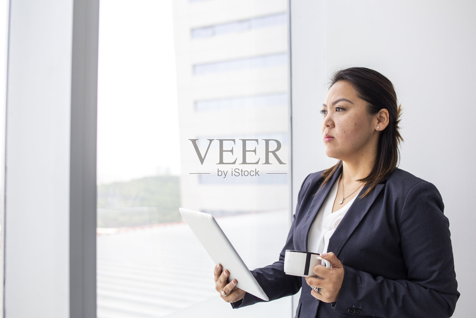 一个日本女人从办公室的窗户往外看照片摄影图片