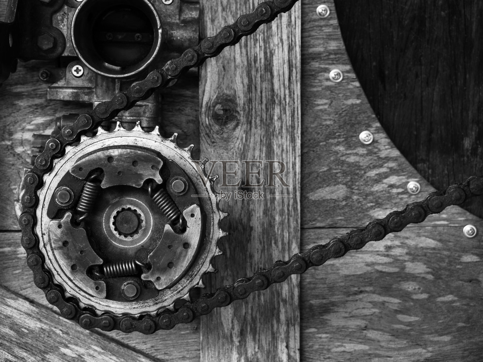 旧生锈齿轮机构安排在木制背景，黑白风格。混合和匹配的背景齿轮，自行车链，机械上的古董木。照片摄影图片