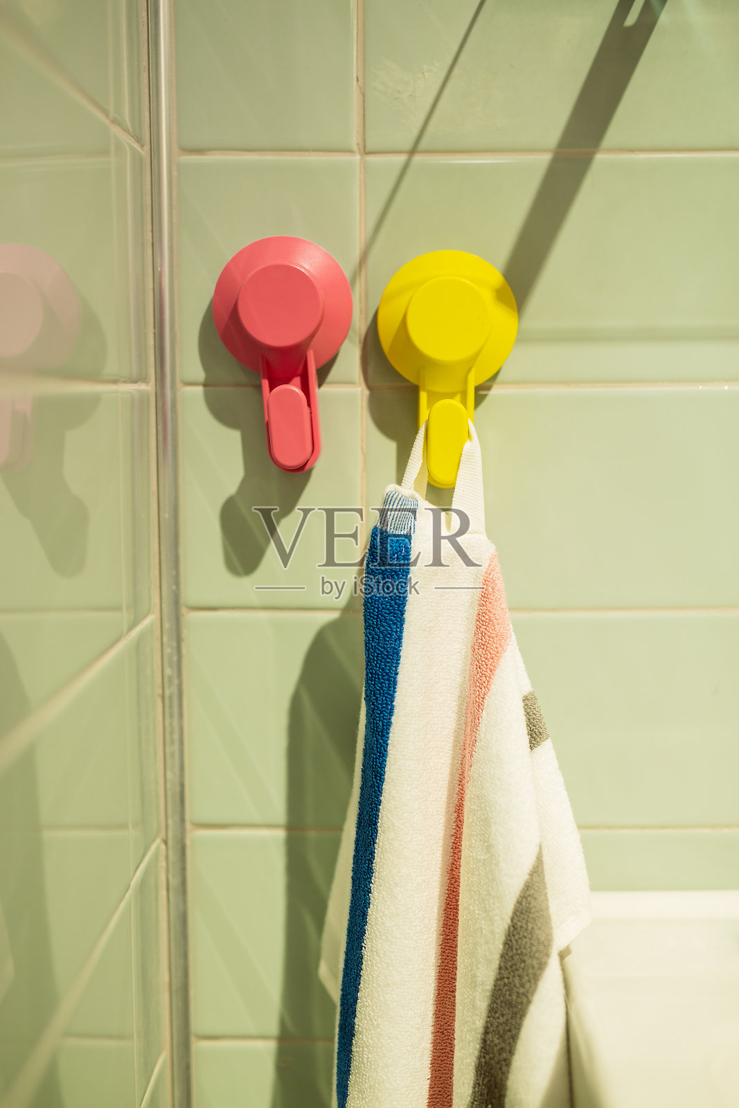 一条白毛巾挂在浴室暖气片旁边的毛巾架上照片摄影图片