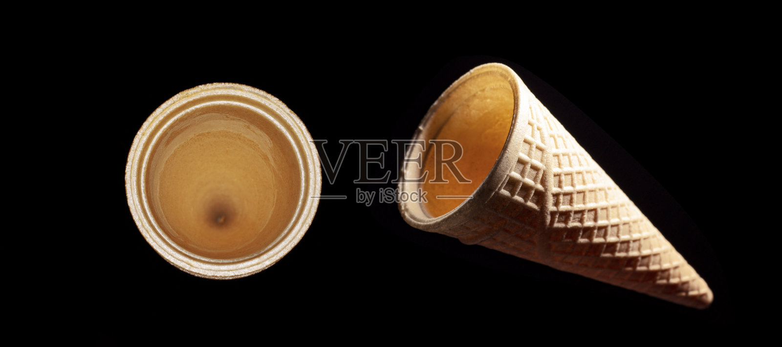 黑色背景上悬挂在空中的华夫饼甜筒照片摄影图片