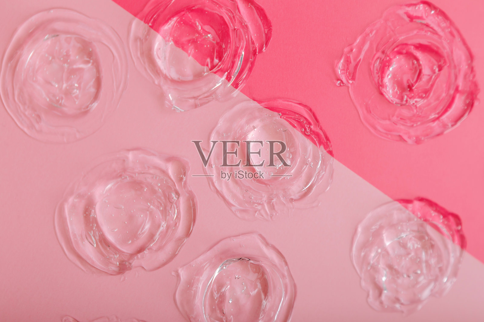 透明色块凝胶纹理在粉红色背景上。护肤化妆品质地胶原蛋白或透明质液体血清。用护肤凝胶制成的圆形样本。照片摄影图片