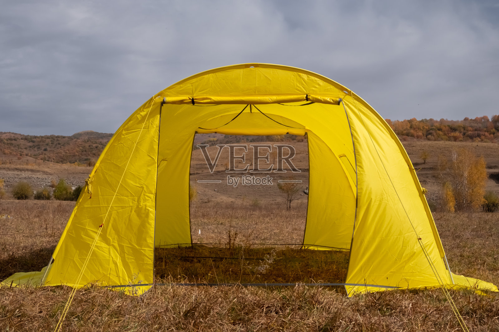 黄色大大本营帐篷在五颜六色的山脉背景。照片摄影图片