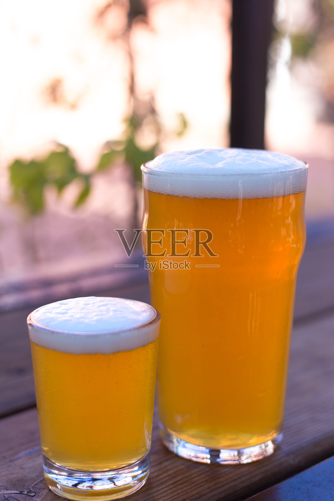 两杯啤酒特写，一大杯，一小杯照片摄影图片