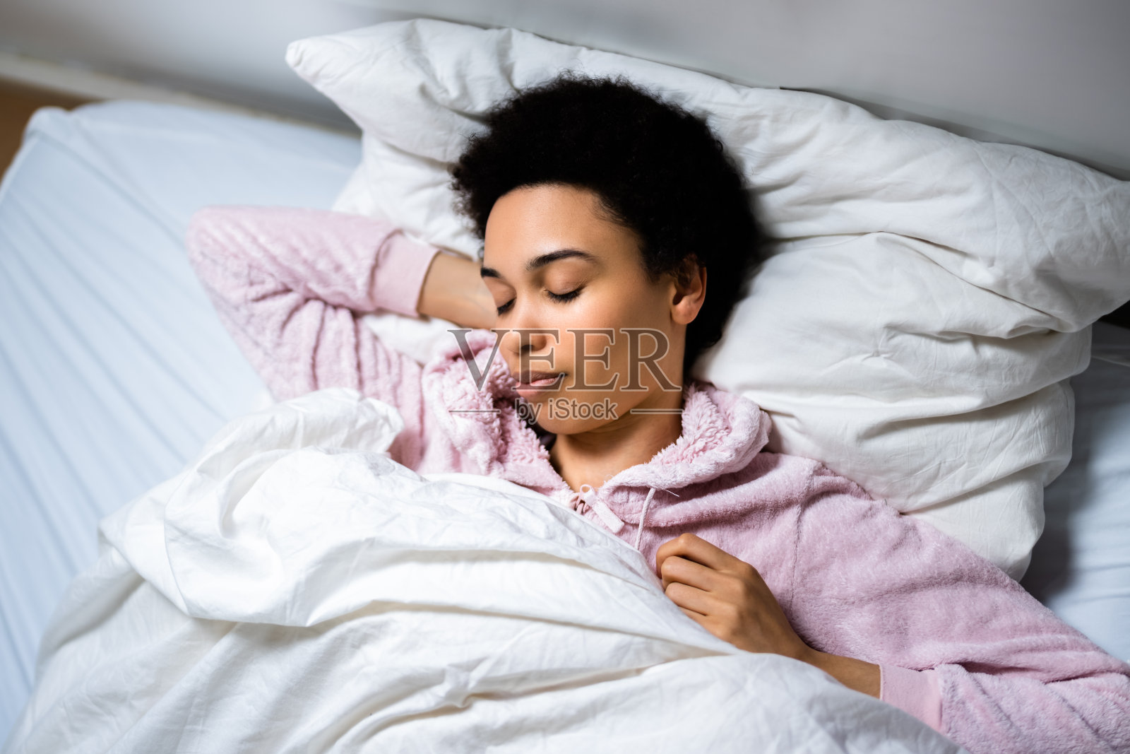 女人在床上枕着枕头睡觉照片摄影图片