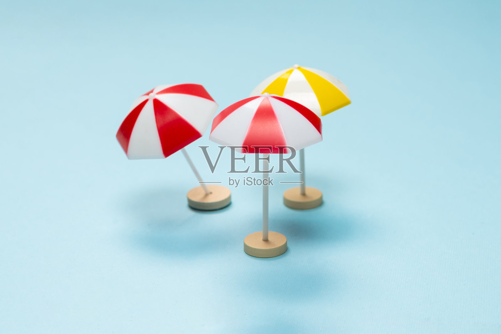 黄色和红色的伞在蓝色的背景上。照片摄影图片