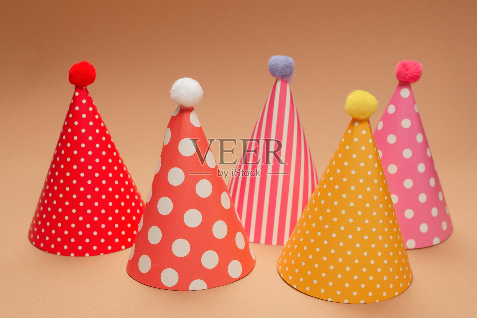 棕色背景的彩色生日帽。照片摄影图片