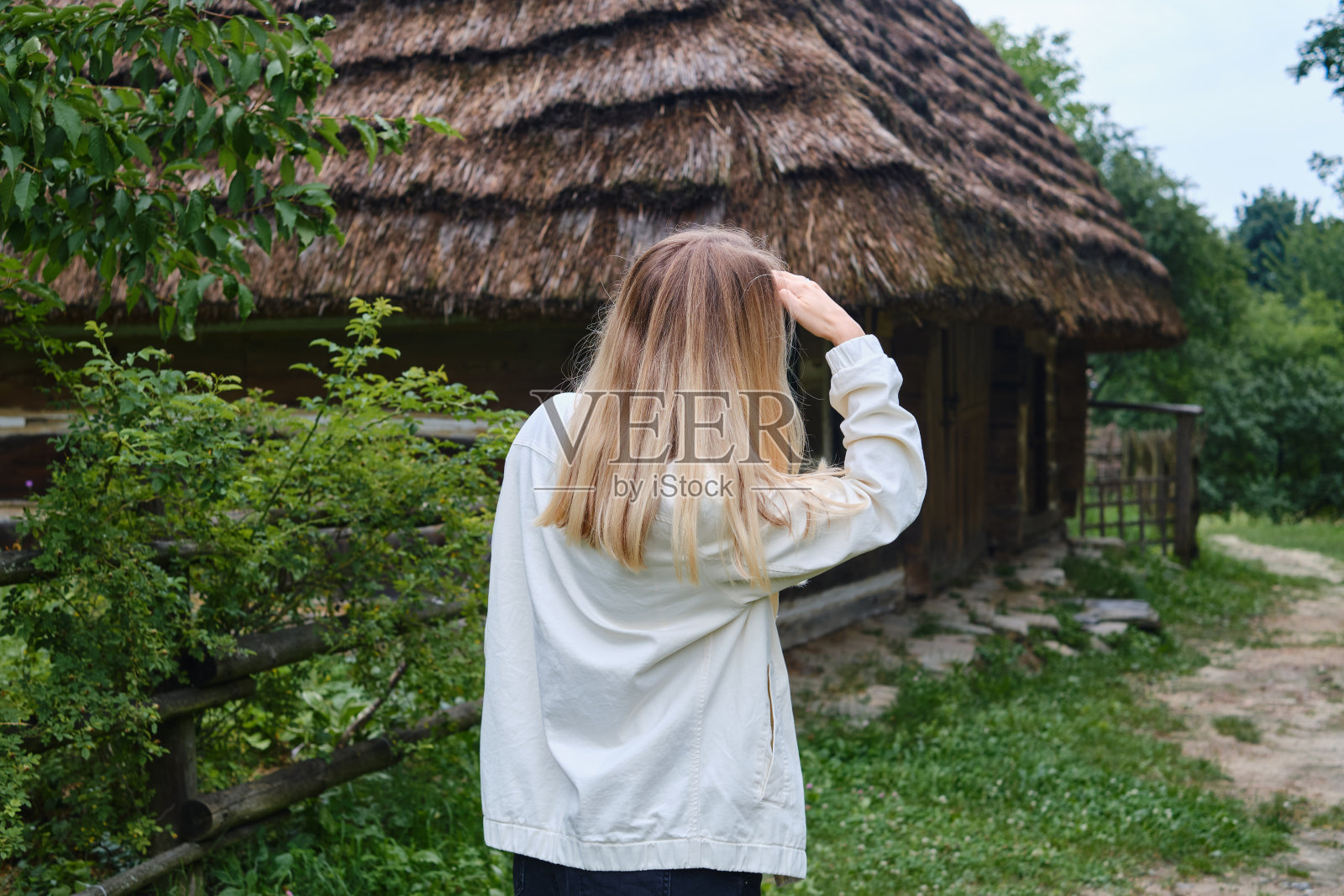 那位美丽的旅行者姑娘穿过村庄。乡村美丽的自然景观。徒步旅行。户外探险。旅行和探索。健康的生活方式照片摄影图片