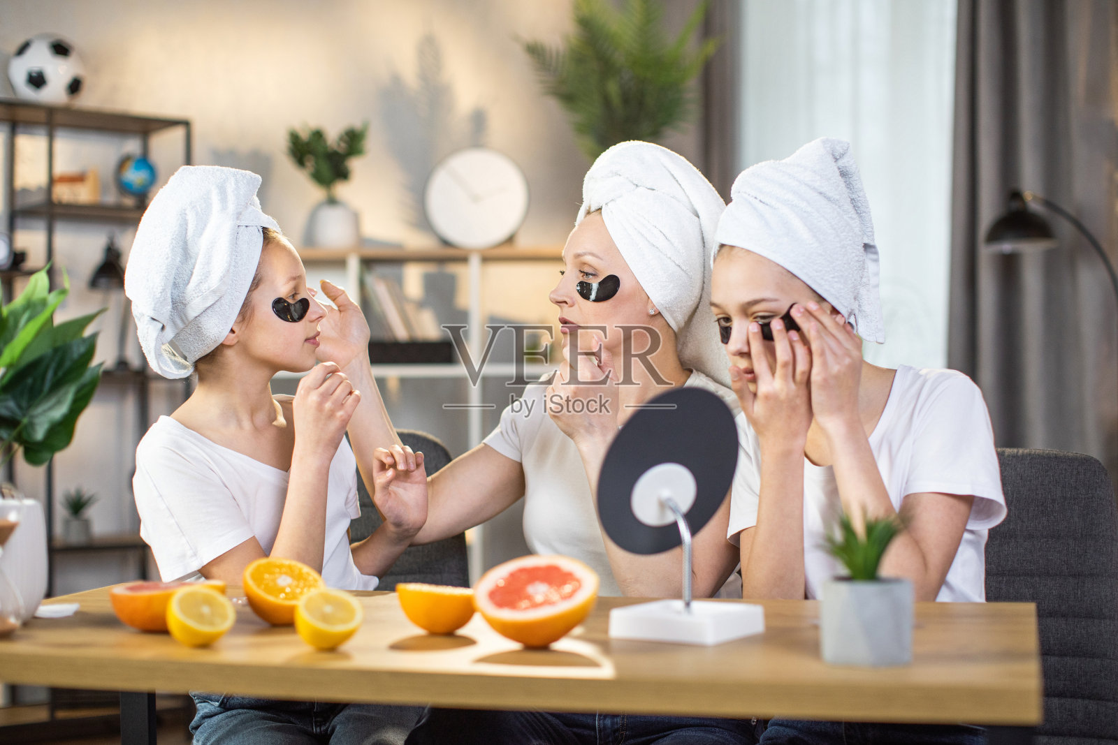 母亲带着女儿在家里用水凝胶眼罩照片摄影图片